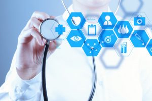 male doctor in a lab coat  holding up a stethoscope to a digital screen that has medical icons showing