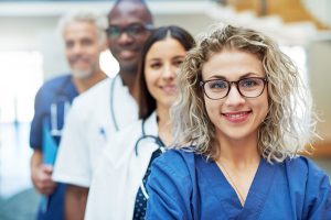 Diverse group of doctors smiling into the camera, waiting to help 